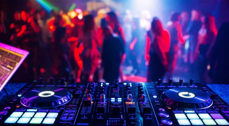Escena de un DJ con sus tocadiscos ante el público en una fiesta de empresa