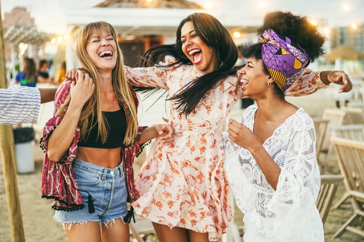Amis multiraciaux heureux s'amusant en plein air à la fête sur la plage lors d'une soirée entreprise