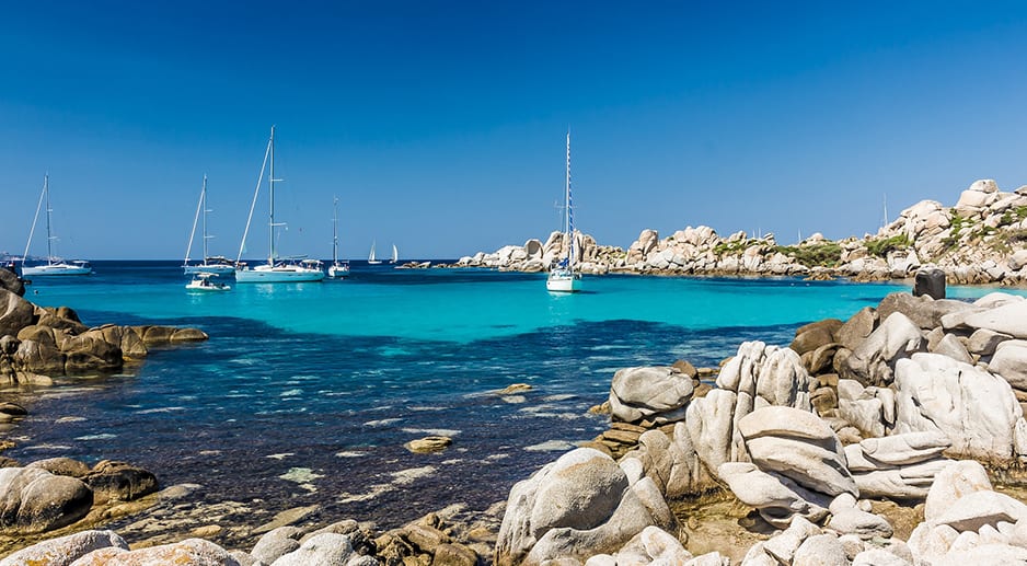 Une crique en Corse avec eau turquoise et voiliers