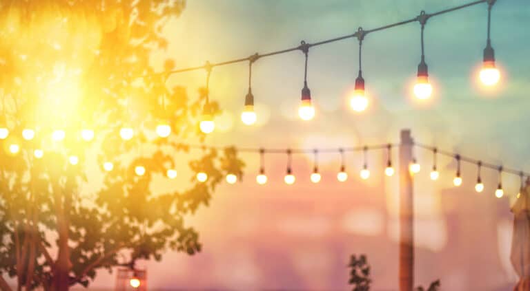 Blurred bokeh light on sunset with yellow tinsel decor