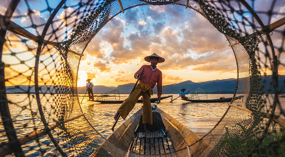 Un pêcheur sur sa barque au coucher de soleil