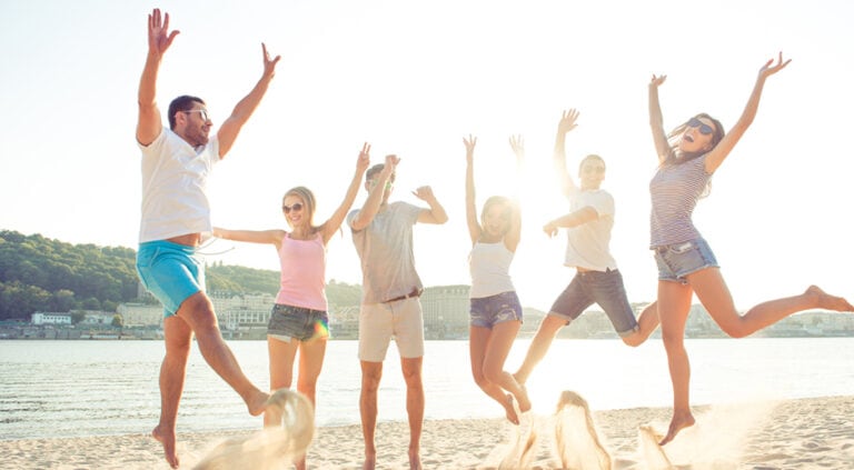 Six people jump in the air on a beach
