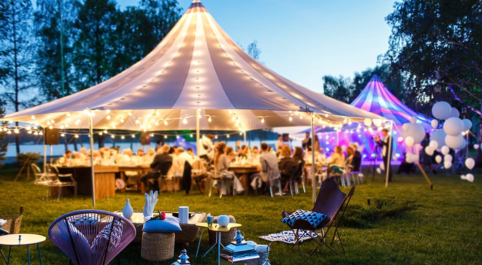 Une soirée lancement de produit dans un parc avec des chapiteaux et du monde en train de dîner