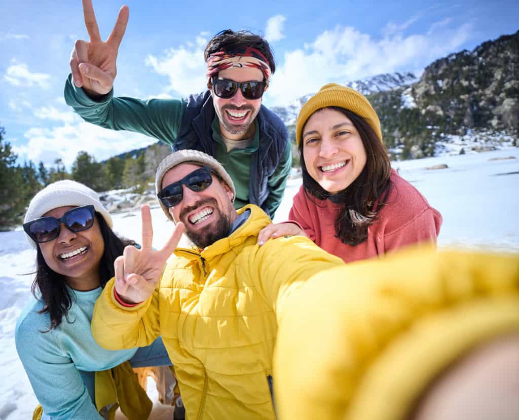Groupe de personnes en train de prendre un selfie lors d'un team building à la neige.