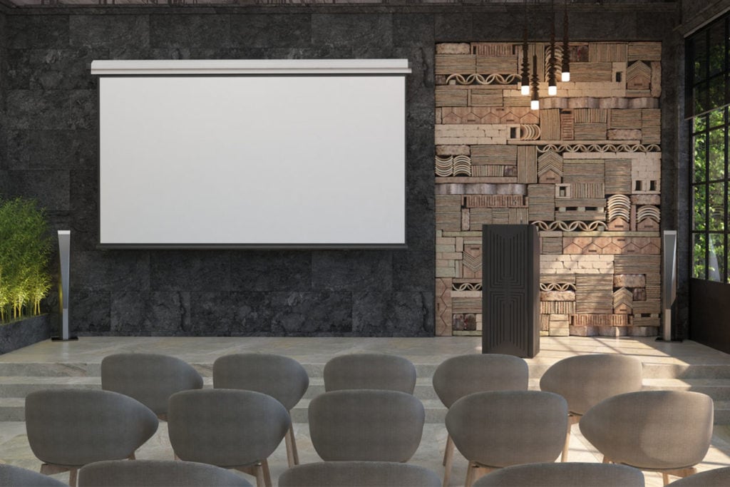 Une salle de séminaire à Bordeaux avec écran blanc blanc pour le projecteur sur le mur noir. L’intérieur de la salle de conférence avec une scène et un stand pour les représentations
