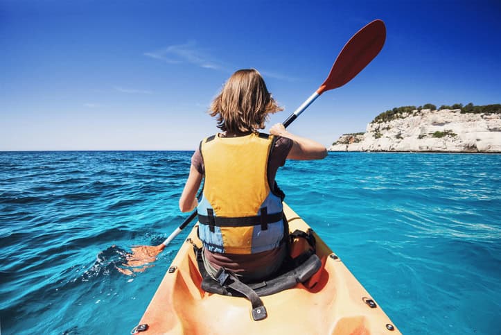 Jeune fille faisant du kayak en mer. Mode de vie actif et concept de voyage.