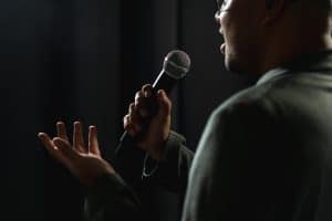 Comédien qui fait du stand up sur une scène pour une animation d'entreprise
