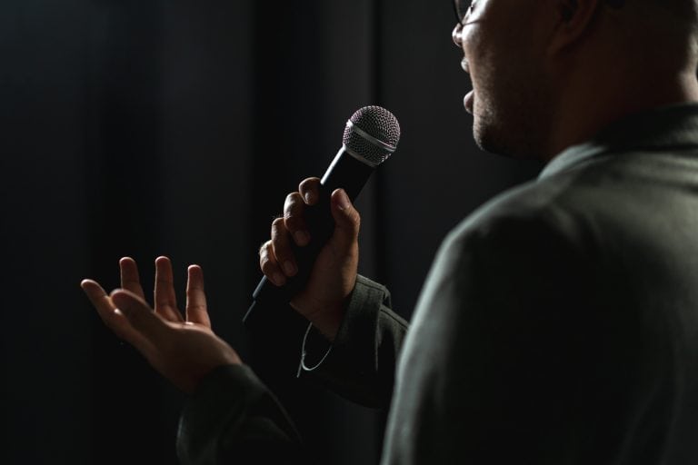Comédien qui fait du stand up sur une scène pour une animation d'entreprise