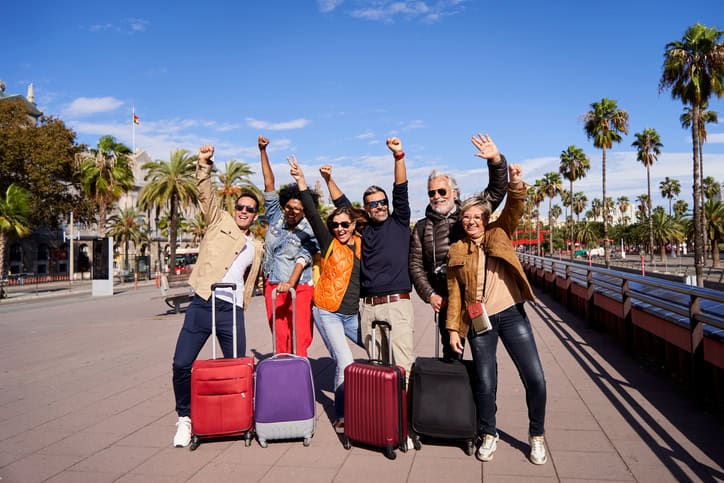 Grupo de empleados de mediana edad posando para la cámara y celebrando alegremente su incentivo.